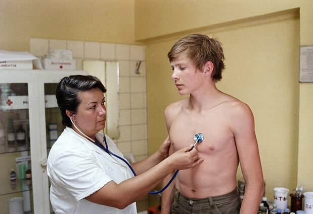 Gydytoja apžiūri berniuką, evakuotą iš Černobylio katastrofos vietos. 1986 m. birželio 14 d. Gydytoja apžiūri berniuką, evakuotą iš Černobylio katastrofos vietos. 1986 m. birželio 14 d.