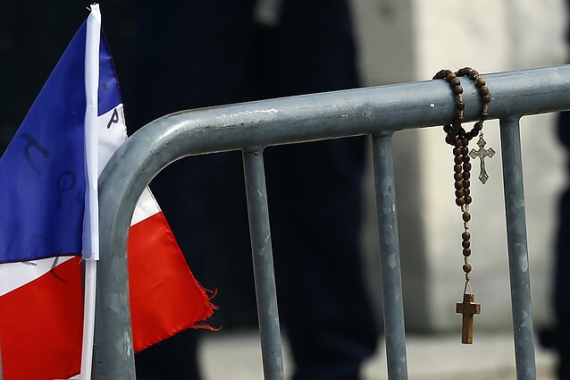 Prancūzijos vėliava ir rožinis prie memorialo priešais Sent Etjen diu Ruvrė bažnyčią Prancūzijos vėliava ir rožinis prie memorialo priešais Sent Etjen diu Ruvrė bažnyčią