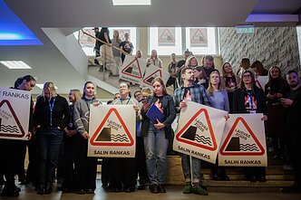 Protestas „Šalin rankas“. LRT darbuotojai LRT tarybą pasitiko su protesto plakatais
