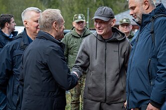 Donaldas Tuskas sutinka Baltarusijos režimo paleistą Andrzejų Poczobutą