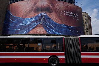 Plakatas Irane, rodantis Hormuzo sąsiaurį ir pašiepiantis JAV prezidentą Donaldą Trumpą