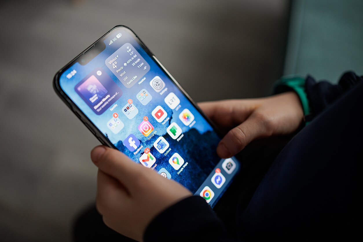 Vaikas su mobiliu telefonu