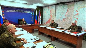 Vladimiras Putinas (fone, centre) lankosi vienoje iš Rusijos jungtinės kariuomenės grupuotės vadaviečių neatskleistoje vietoje Vladimiras Putinas (fone, centre) lankosi vienoje iš Rusijos jungtinės kariuomenės grupuotės vadaviečių neatskleistoje vietoje