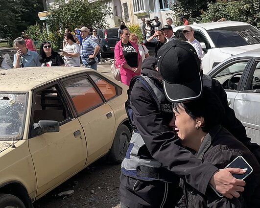 Policijos psichologė guodžia mamą, išgyvenančią dėl vaikų, buvusių raketos sugriauto namo bute