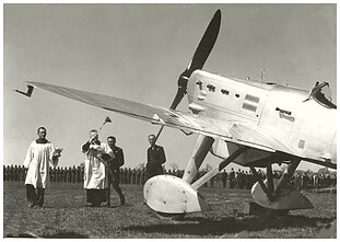 1937 m. Kauno aerodrome krikštijami naujieji naikintuvai „Dewoitine D-501L“. Kapelioną lydi Leonardas Peseckas ir Jonas Mikėnas 1937 m. Kauno aerodrome krikštijami naujieji naikintuvai „Dewoitine D-501L“. Kapelioną lydi Leonardas Peseckas ir Jonas Mikėnas